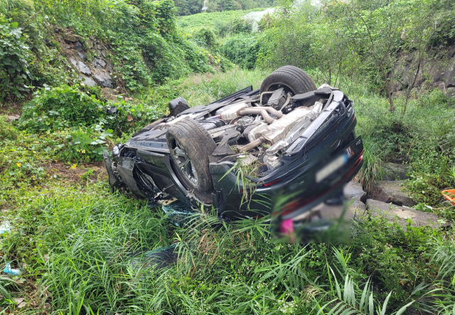 25일 부산 기장군의 한 도로에서 SUV 차량이 가드레일을 뚫고 6m 아래로 추락해 탑승자 2명이 숨졌다. 부산 기장경찰서 제공