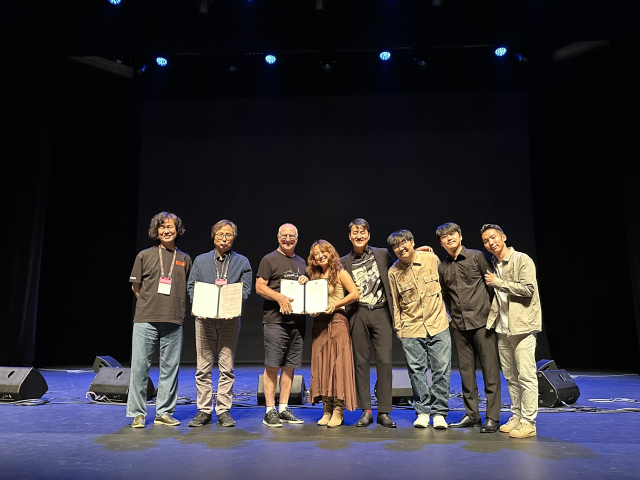 2025 부산국제공연예술마켓(BPAM, 비팜)을 통해 해외 초청이 결정된 블루그래스 밴드 '컨트리공방'과 이 단체를 초청한 프랑스의 ‘라로슈 블루그래스 페스티벌’을 설립한 크리스토퍼 하워드-윌리엄스 회장 겸 예술감독이 27일 오후 부산문화회관 중극장에서 MOU를 체결한 뒤 기념사진을 찍고 있다. 사진 왼쪽부터 조희창 비팜 프로그래머(음악), 오재환 부산문화재단 대표이사, 크리스토퍼 하워드 윌리엄스, 컨트리공방 멤버들. 김은영 기자 key66@