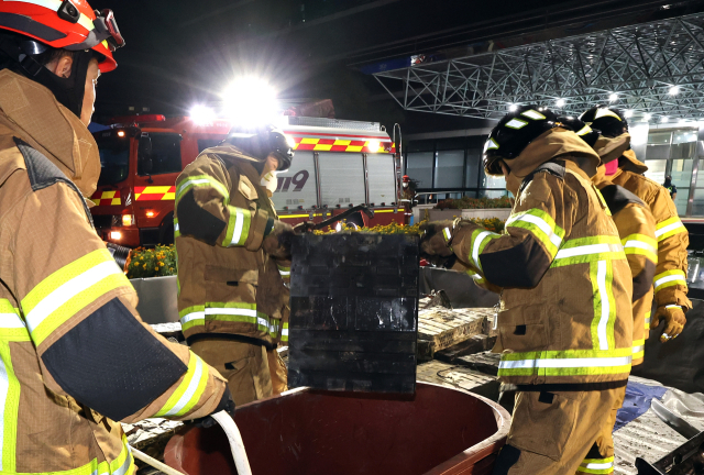 27일 밤 대전 유성구 국가정보자원관리원 화재 현장에서 소방대원들이 불에 탄 리튬이온 배터리를 소화수조로 옮기고 있다. 연합뉴스