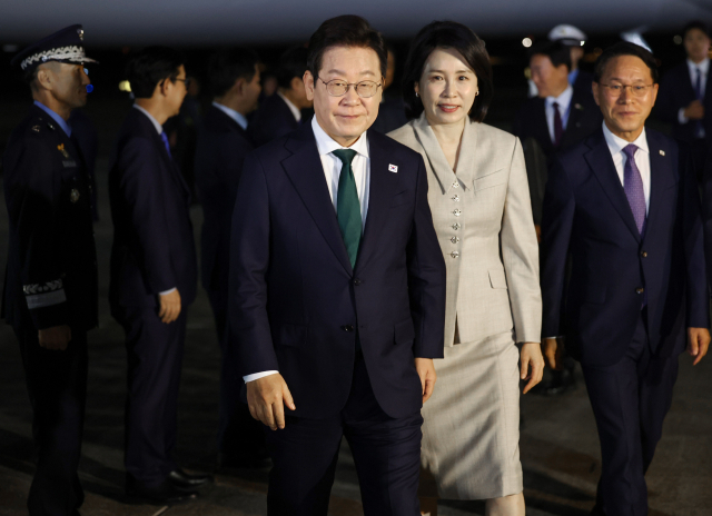 미국 방문 일정을 마치고 귀국한 이재명 대통령과 김혜경 여사가 지난 26일 성남 서울공항에 착륙한 공군 1호기에서 내려 이동하고 있다. 연합뉴스