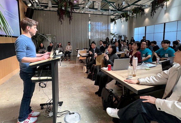 지난해 열린 스타트업 행사에서 오픈AI 샘 알트먼(왼쪽) 대표와 마리나체인 직원들이 대화하고 있다. 마리나체인 제공