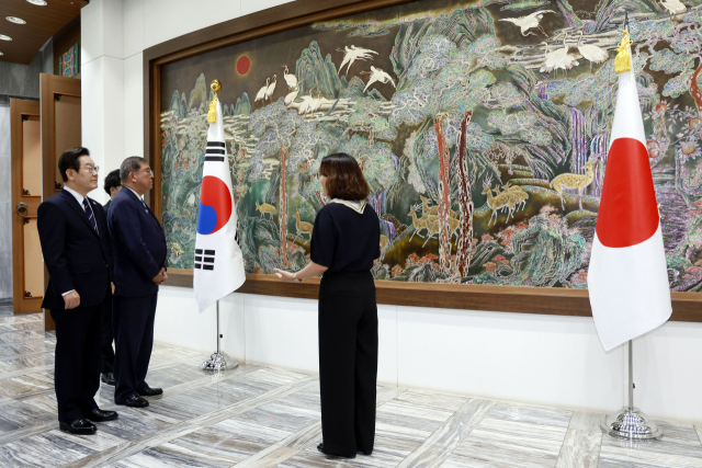 이재명 대통령과 이시바 시게루 일본 총리가 30일 부산 누리마루 APEC 하우스 기념관에서 문화 관광 해설사로부터 김규장 나전칠기 명장의 ‘십이장생도’에 대한 설명을 듣고 있다.연합뉴스