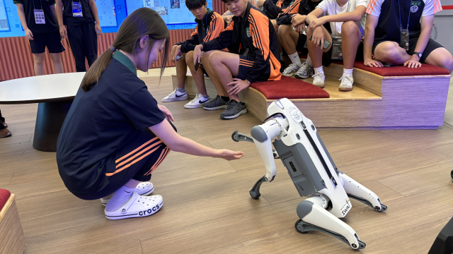1일 오전 11시 부산 북구 SW·AI교육거점센터 1층 XR 스테이지에서 이사벨중학교 학생이 손을 뻗자 로봇개가 앞발을 내밀며 반응하고 있다. 이상배 기자 sangbae@busan.com