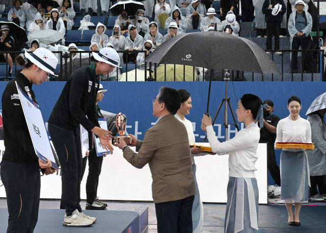 현대차그룹 장재훈 부회장이 3일 광주 동구 5·18 민주광장 특설경기장에서 열린 ‘현대자동차 정몽구배 한국양궁대회 2025’ 여자 리커브 결승전에서 우승을 차지한 임시현 선수에게 우승 트로피를 수여하며 축하하고 있다. 이 대회는 2016년 창설 이래 국내 양궁 선수들의 경기력 강화와 한국 양궁 저변 확대에 기여해 왔다.현대차 제공