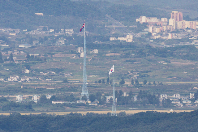 지난달 22일 경기도 파주시 접경지역에서 바라본 서부전선 비무장지대(DMZ)에서 남측 대성동 마을 태극기와 북측 기정동 마을 인공기가 펄럭이고 있다. 연합뉴스