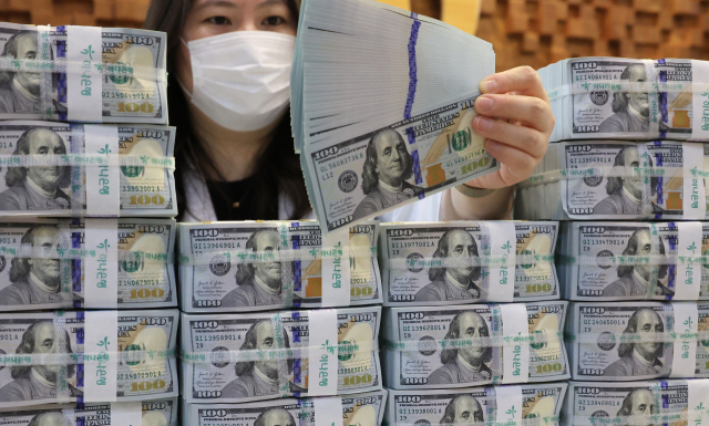 서울 명동 KEB하나은행 위변조대응센터에서 직원이 미국 달러를 들어보이고 있다. 연합뉴스