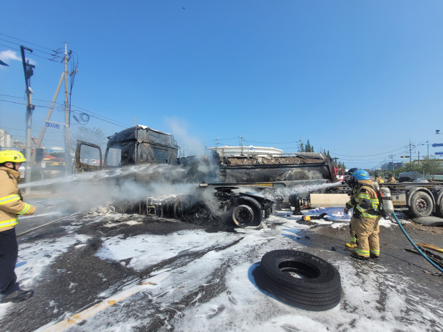 11일 울산 남구 용연사거리에서 덤프트럭과 트레일러가 충돌한 뒤 화재가 발생하자, 소방대원들이 소화액을 뿌리며 진화작업을 마무리하고 있다. 울산소방본부 제공