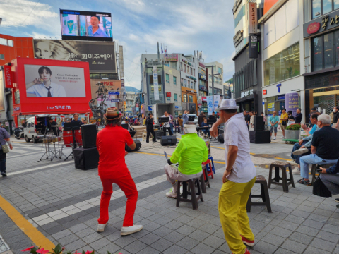 광복로 거리 공연에 어르신들이 백댄서가 되어 춤을 추며 즐기고 있다.
