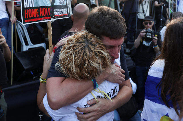 13일(현지 시간) 이스라엘 텔아비브 인질 광장에서 시민들이 가자지구에 억류돼 있던 이스라엘 인질들이 돌아오기를 기다리고 있다. 로이터