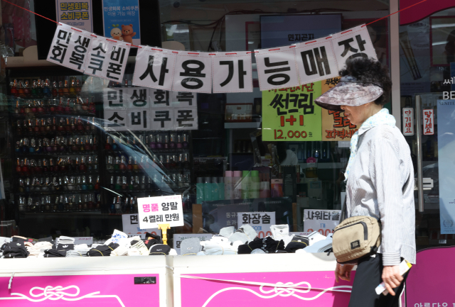 서울 한 전통시장 상점에 붙은 민생회복 소비쿠폰 사용 안내문 모습. 연합뉴스