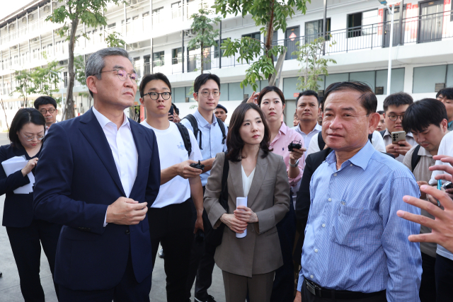 김진아 외교부2차관, 박성주 경찰청 국가수사본부장을 비롯한 정부 합동대응팀 구성원들이 지난 16일(현지시간) 캄보디아 프놈펜 인근 범죄단지인 태자단지에서 팡 나렌 온라인스캠대응위 사무차장(오른쪽 첫 번째 파란 셔츠)의 설명을 듣고 있다. 연합뉴스