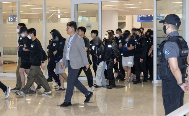 캄보디아 온라인 사기에 가담해 구금된 한국인들이 18일 오전 인천국제공항 제2터미널을 통해 송환되고 있다. 이날 송환에는 경찰 호송조 190여명이 투입됐다. 연합뉴스