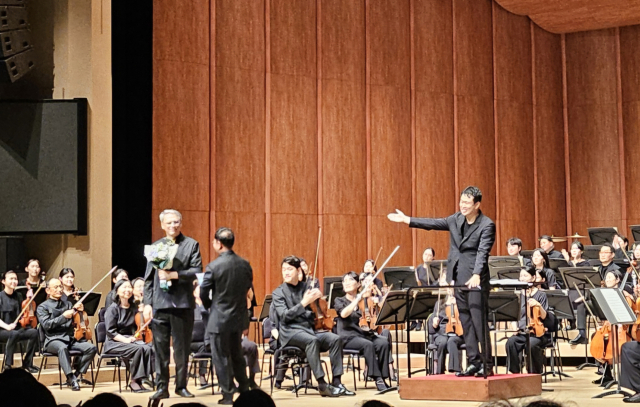 드미트리가 지난 6월 19일 부산문화회관에서 열린 부산시향 제621회 정기연주회를 마친 뒤 정년 퇴임을 기념해 동료들로부터 꽃다발을 받고 있다. 드미트리 제공