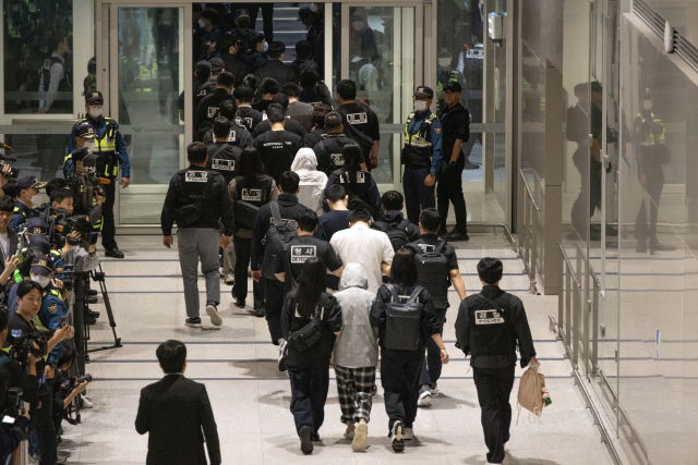 캄보디아 온라인 사기에 가담해 구금된 한국인들이 18일 오전 인천국제공항 제2터미널을 통해 송환되고 있다. 이날 송환에는 경찰 호송조 190여명이 투입됐다. 연합뉴스