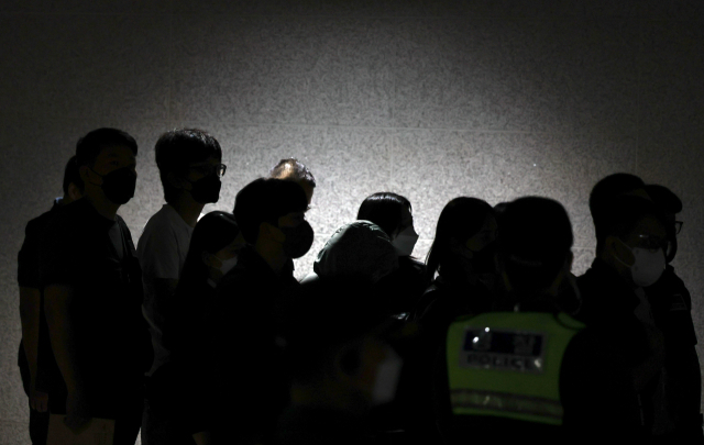 캄보디아 온라인 사기에 가담해 구금된 한국인들이 18일 오전 인천국제공항 제2터미널을 통해 송환돼 호송차로 향하고 있다. 이날 송환에는 경찰 호송조 190여명이 투입됐다. 연합뉴스