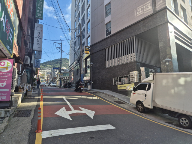 20일 오후 A 아파트에서 양정초등학교로 가는 주요 통학로. 별다른 보행자 보호 시설이 없는 좁고 가파른 길로 차량들이 지나다니고 있다. 김동우 기자