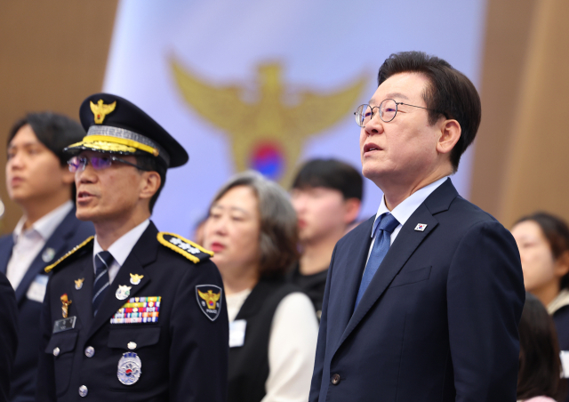 이재명 대통령이 21일 서울 서대문구 경찰청에서 열린 80주년 경찰의 날 기념식에서 애국가를 부르고 있다. 왼쪽은 유재성 경찰청장 직무대행. 연합뉴스