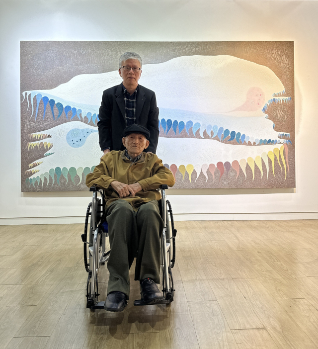 21일 금련산역갤러리에서 열린 ‘서재만 회고전: 묻혔습니다' 개막식에 휠체어를 타고 참석한 서재만 화백과 그의 아들 서유억 씨. 김은영 기자 key66@