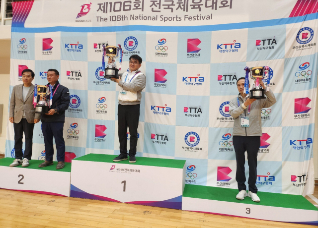 제106회 부산 전국체전에 참가한 부산 탁구선수단이 39년 만에 종합우승을 달성했다. 부산시 탁구협회 박종우 회장이 1등 단상에 올라 우승 트로피를 들어보이고 있다. 부산시체육회 제공