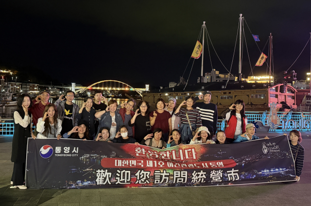경남관광재단이 운영하는 체류형 여행 상품을 통해 통영을 방문한 대만 관광개들이 강구안 문화마당 야경을 감상한 뒤 기념촬영을 하고 있다. 통영시 제공