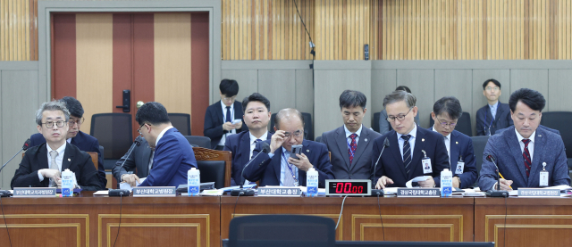 부산대학교 최재원 총장 등이 23일 경남 창원시 경남도교육청 2층 강당에서 열린 국회 교육위원회의 부산대·부산대병원·부산대치과병원·경상국립대·경상국립대병원 국정감사에 앞서 자료를 살피고 있다. 연합뉴스