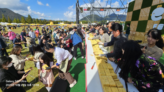 부산일보 손영신 대표이사와 윤영석 국회의원, 나동연 양산시장, 도·시의원, 박원현 양산시민통합위원회 위원장 등이 25일 대형 계란말이 커딩식 후 시민들에게 나눠주고 있다. 김태권 기자