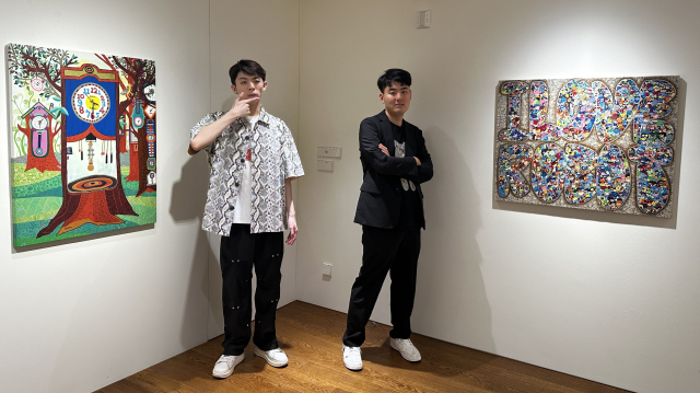 스페이스 토핑에서 열리고 있는 ‘감각, 기록자들’ 전시 초대 작가 윤진석·황성제 작가가 본인 작품 앞에서 포즈를 취했다. 김은영 기자 key66@