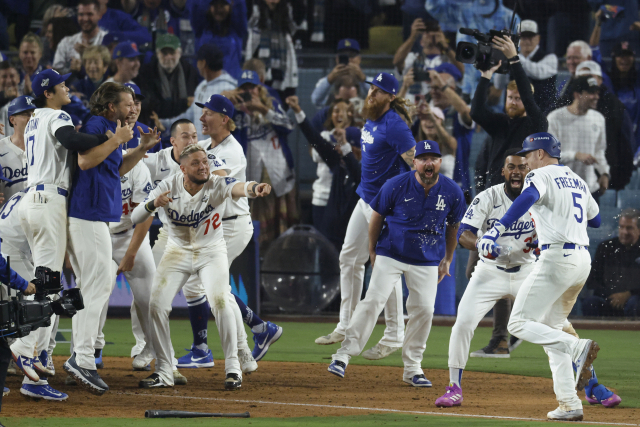 LA 다저스 프레디 프리먼(오른쪽)이 28일(한국 시간) 미국 로스앤젤레스의 다저스타디움에서 열린 2025 미프로야구 메이저리그 토론토 블루제이스와의 월드시리즈 3차전에서 연장 18회말 결승 홈런을 때린 뒤 동료들의 뜨거운 환영 속에 홈을 향해 달리고 있다. EPA연합뉴스