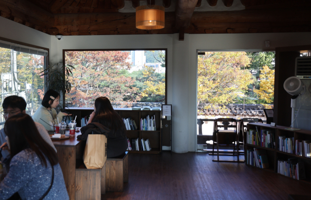 김해시 봉황동 한옥카페 명월 2층. 통창 밖으로 왕릉길 돌담과 단풍이 든 나무들이 보인다. 이재찬 기자 chan@