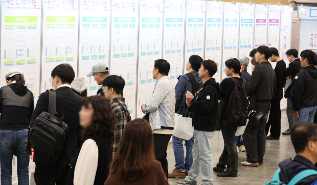 ‘2025 부산 잡(JOB) 페스티벌’이 열린 지난달 27일 부산 해운대구 벡스코 제1전시장에서 구직자들이 채용기업 현황판을 살펴보고 있다. 연합뉴스