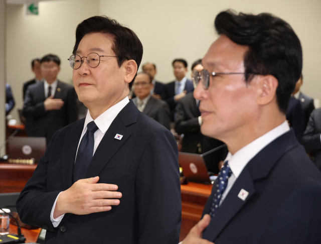 이재명 대통령이 4일 용산 대통령실에서 열린 국무회의에서 국기에 경례하고 있다. 오른쪽은 김민석 총리. 연합뉴스