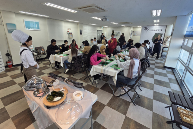 부산 공수마을 관광패키지에 참가한 외국인 관광객이 다시마장아찌 만들기 체험을 하고 있다. 어촌어항공단 제공