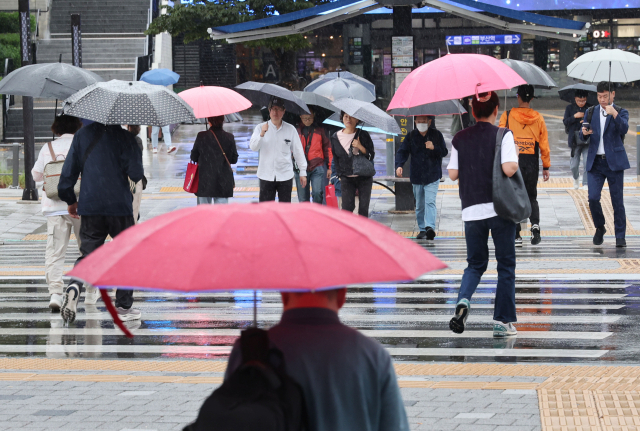 가을비가 내리며 흐린 날씨가 이어진 지난달 14일 오전 부산 동구 부산역 앞에서 시민들이 우산을 쓰고 횡단보도를 지나가고 있는 모습. 정종회 기자 jjh@