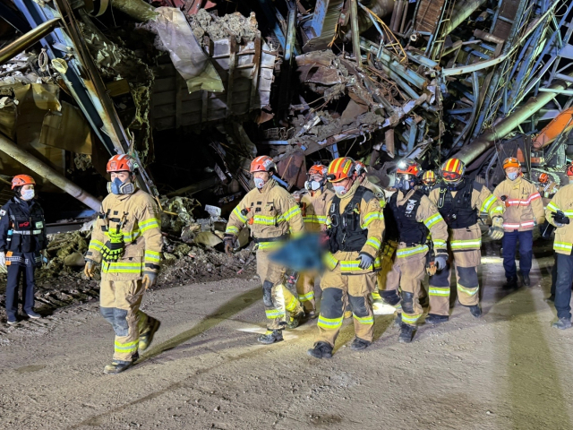 13일 새벽 울산 동서발전 화력발전소 붕괴 사고 현장에서 소방 구조대원들이 사고 발생 7일 만에 추가로 수습된 30대 김 모 씨의 시신을 수습해 나오고 있다. 울산소방본부 제공