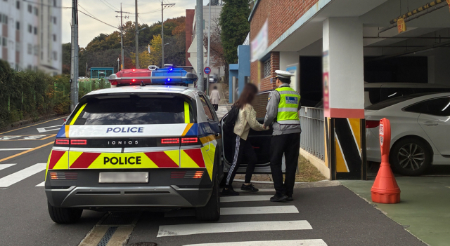 2026학년도 대학수학능력시험일인 13일 오전 울산의 한 고사장 인근에서 경찰관이 긴급 수송한 수험생의 하차를 돕고 있다. 울산경찰청 제공