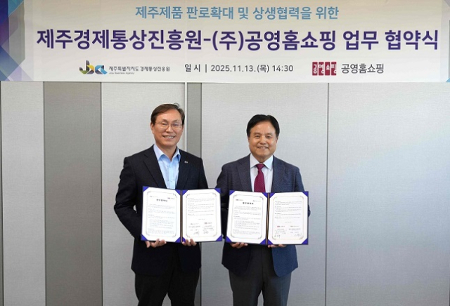 김영주 공영홈쇼핑 대표이사 직무대행(오른쪽)과 고병기 제주특별자치도 경제통상진흥원장이 협약서에 서명한 후 기념촬영을 하고 있다. 공영홈쇼핑 제공