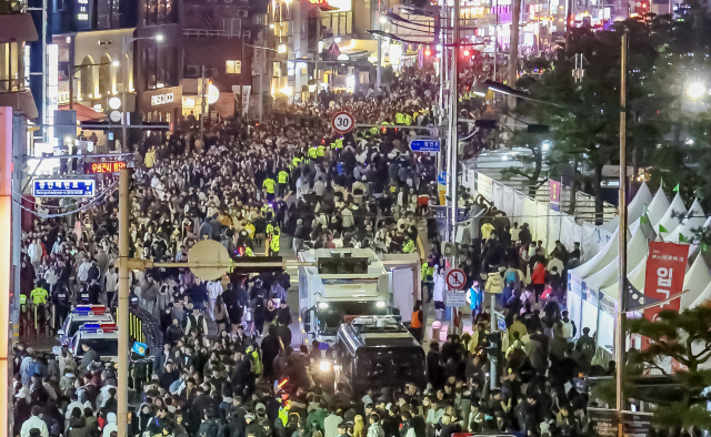 제20회 부산불꽃축제가 열린 15일 부산 수영구 광안리해수욕장 도로에서 관람객들이 귀가하고 있다. 김종진 기자 kjj1761@