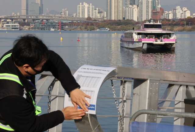 16일 서울 송파구 잠실선착장에서 주변에서 한강버스가 강바닥에 걸려 멈추자 관계자가 운항 중단 안내문을 붙이고 있다. 연합뉴스