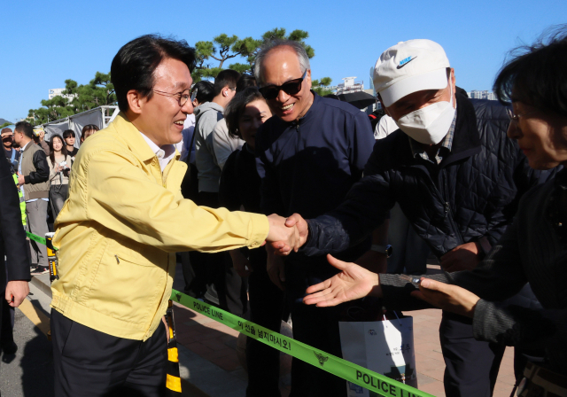 김민석 국무총리가 지난 15일 부산 광안리해수욕장 일대를 돌아보며 부산불꽃축제 안전관리상황을 점검하던 중 시민들과 인사를 나누고 있다. 연합뉴스