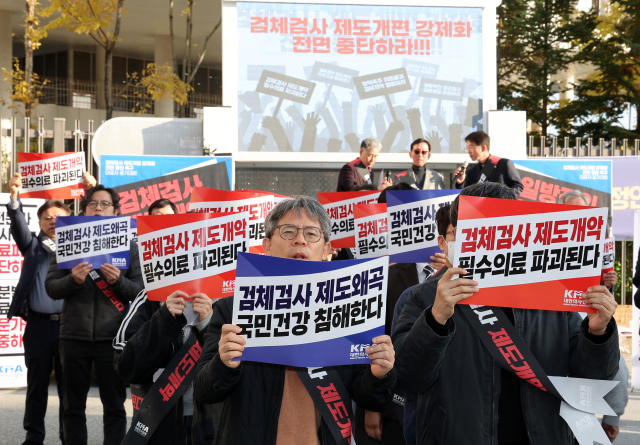 김택우 대한의사협회 회장(오른쪽)을 비롯한 의사들이 11일 정부세종청사 보건복지부 앞에서 열린 '검체검사 제도개편 강제화 전면 중단 촉구 대표자 궐기대회'에서 구호를 외치고 있다. 연합뉴스