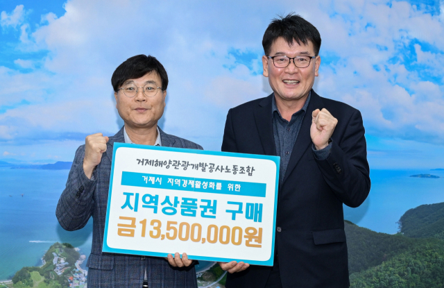 거제시 지방공기업인 거제해양관광개발공사 노조가 공사 창립 13주년을 맞아 거제사랑상품권 1350만 원어치를 구매해 전 임직원에게 전달했다. 공사 이종진 노조위원장(오른쪽)과 변광용 거제시장이 기념 촬영을 하고 있다. 공사 제공