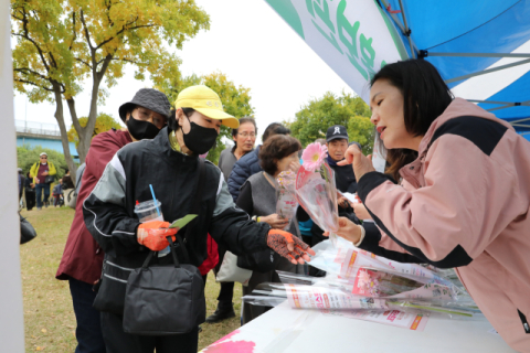 부산과기대 홍보관을 방문한 지역 주민에 국화꽃을 나누는 모습. 부산과학기술대학교 제공