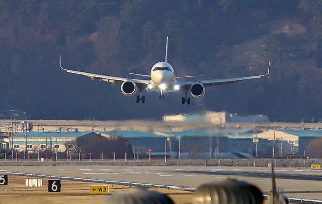 다음 달부터 가덕신공항 부지 조성 공사의 입찰, 사업자 선정 등 일정이 본격 진행될 전망이다. 가덕신공항 간담회에서 발언하는 김윤덕 국토교통부 장관(위)과 김해국제공항에 항공기가 착륙하는 모습. 연합뉴스·부산일보DB