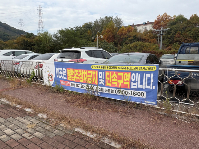 KTX 진영역 주차장 앞에 부착된 불법 주차 단속 알림 현수막. 이경민 기자