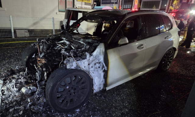 28일 새벽 울산 남구 달동의 한 지상주차장에 세워져 있던 2025년식 BMW 하이브리드 차량이 화재로 인해 전면부가 형체를 알아볼 수 없을 정도로 심하게 훼손되어 있다. 울산소방본부 제공