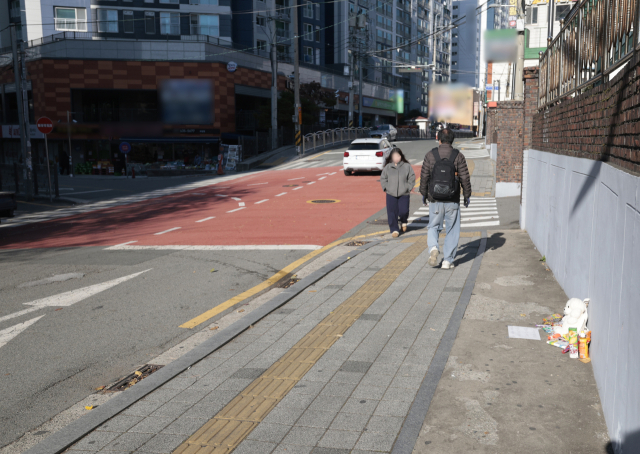 이달 24일 유턴하던 차량에 초등학생이 치어 숨진 사고가 발생한 부산 남구 우암동 한 아파트 앞 사고현장. 숨진 아이를 추모하는 물품이 사고 현장 인근 길가에 놓여 있다. 정대현 기자 jhyun@