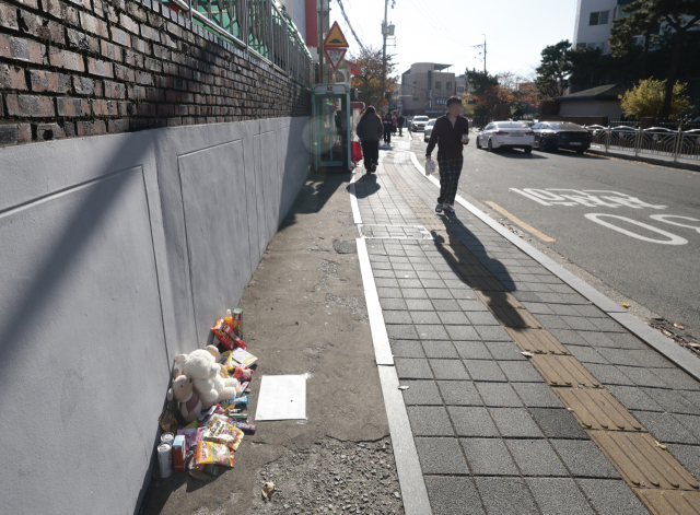 이달 24일 유턴하던 차량에 초등학생이 치어 숨진 사고가 발생한 부산 남구 우암동 한 아파트 앞 사고 현장. 숨진 아이를 추모하는 물품이 사고 현장 인근 길가에 놓여 있다. 정대현 기자 jhyun@