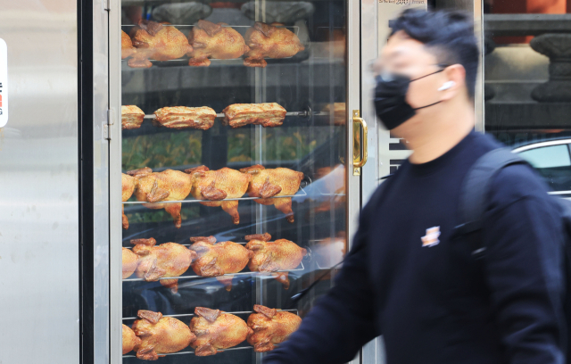 서울 종로에서 시민이 치킨집 앞을 지나고 있다. 연합뉴스