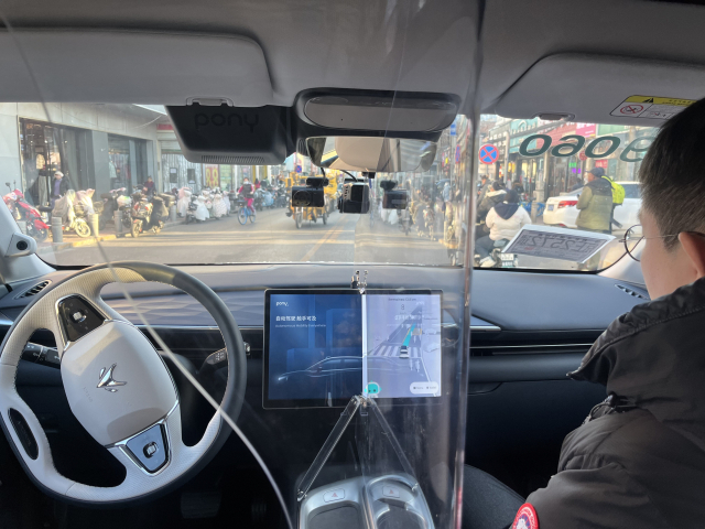 포니AI사의 7세대 택시 아크폭스 외관(위). 취재진이 탑승한 포니AI사의 7세대 택시 아크폭스가 현지 마취아오 시장을 주행하는 모습. 불법 주정차 차량과 자전거가 뒤섞인 좁은 2차로 도로에서 능숙하게 주행했다.