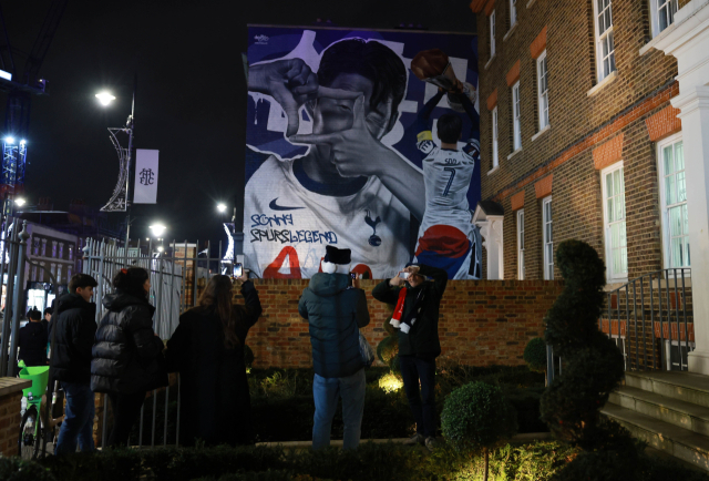 9일(한국 시간) 손흥민의 업적을 기리기 위해 영국 런던의 토트넘 하이로드에 그려진 ‘손흥민 벽화’ 앞에서 팬들이 기념 촬영을 하고 있다. 연합뉴스